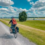 Das Bild zeigt einen Radfahrer an den großen Au-Wiesen des Rheins