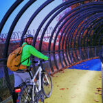 Das Foto zeigt einen Radfahrer auf der beleuchteten Brücke Slinky Springs to Fame in Oberhausen