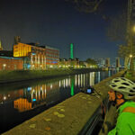 Das Foto zeigt einen Radfahrer beim Fotografieren im dunklen Innenhafen Duisburg