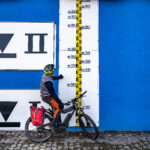 Das Foto zeigt einen Radfahrer an den Hochwassermarkierungen des Rheins in Duisburg