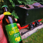 Das Foto zeigt ein Bier und eine alte Lore vor der ungewöhnlichen Unterkunft Herbert des Gästehauses Marina Rünthe in Bergkamen