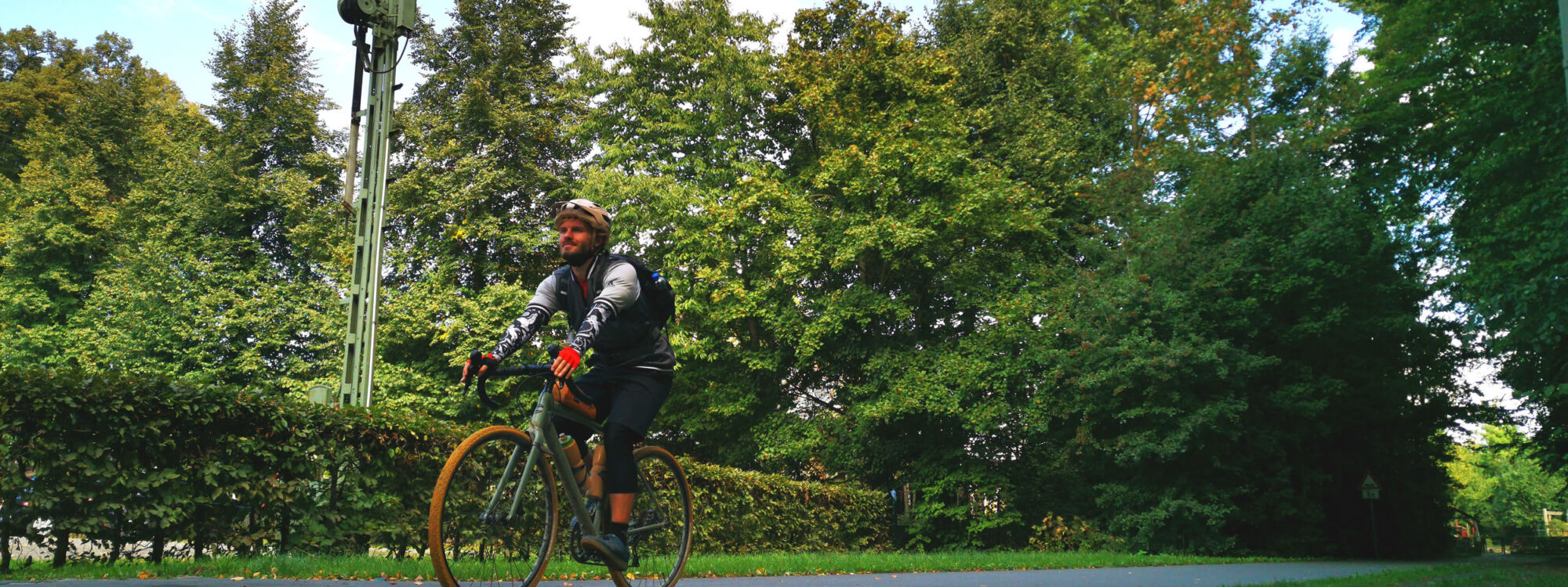 Das Foto zeigt einen Radfahrer beim Bahntrassenradeln auf dem Alleenradweg, der ehemaligen Westfälischen Eisenbahn in Bönen