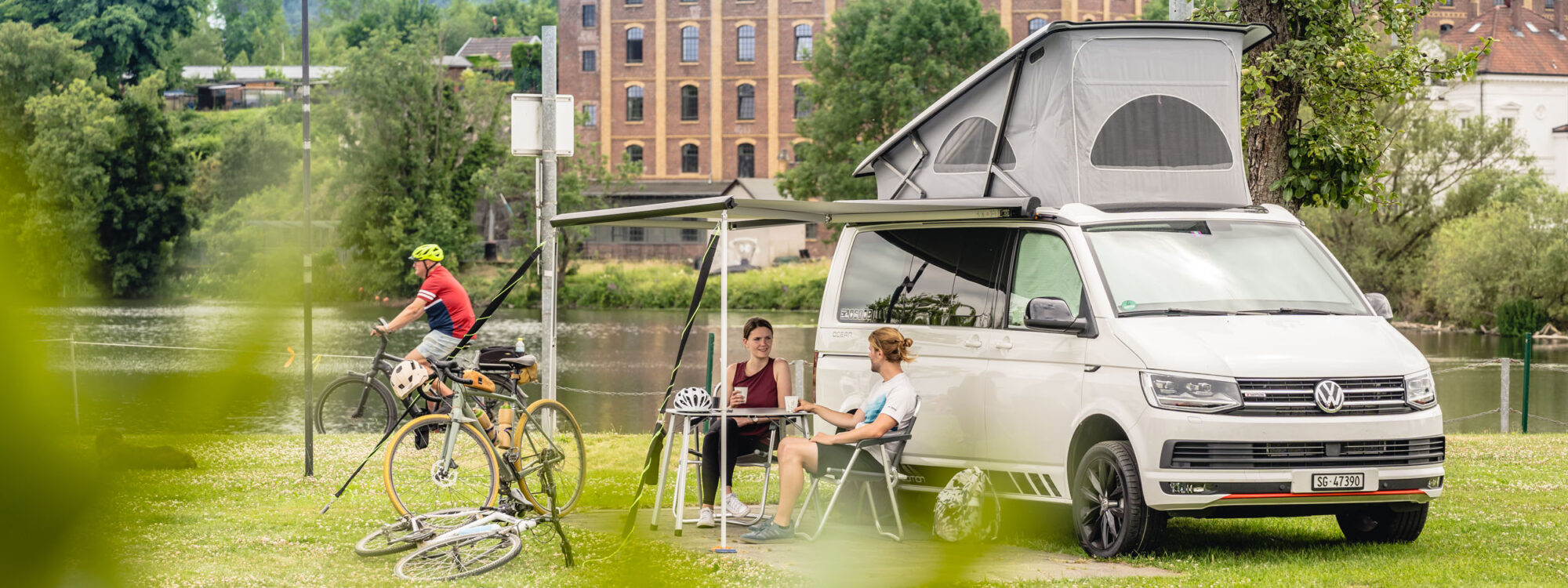 Das Foto zeigt Radfahrende beim Camping mit Bulli auf einem Campingplatz in Hattingen an der Ruhr