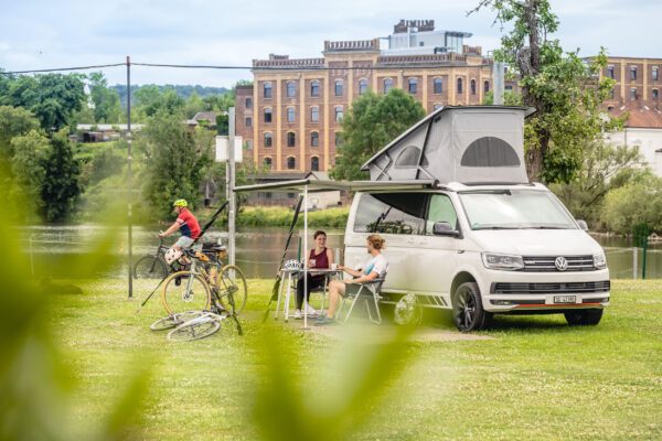 Das Foto zeigt Radfahrende beim Camping mit Bulli auf einem Campingplatz in Hattingen an der Ruhr