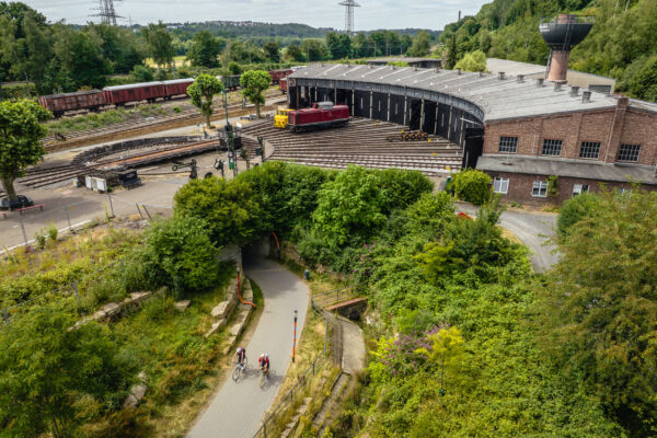 Das Foto zeigt zwei Radfahrende am Eisenbahnmuseum Bochum auf der RevierRoute Bahngeschichte(n)