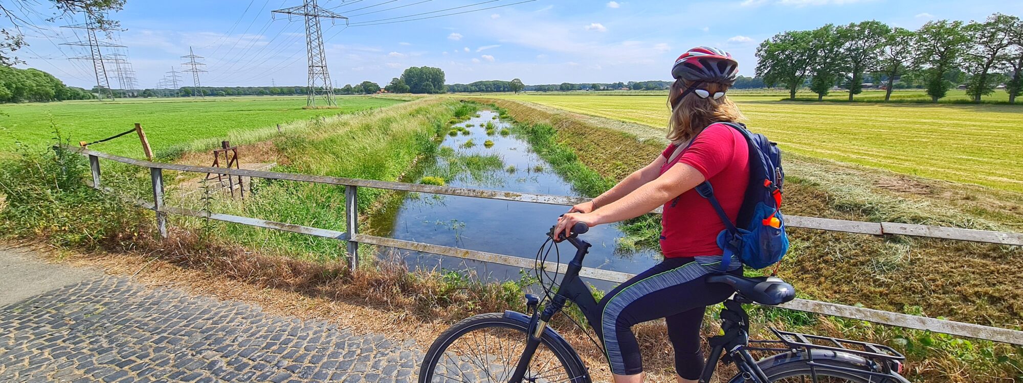 Das Foto zeigt eine Radfahrerin auf der Entdeckertour zwischen Rhein und Issel
