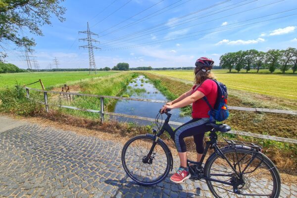 Das Foto zeigt eine Radfahrerin auf der Entdeckertour zwischen Rhein und Issel