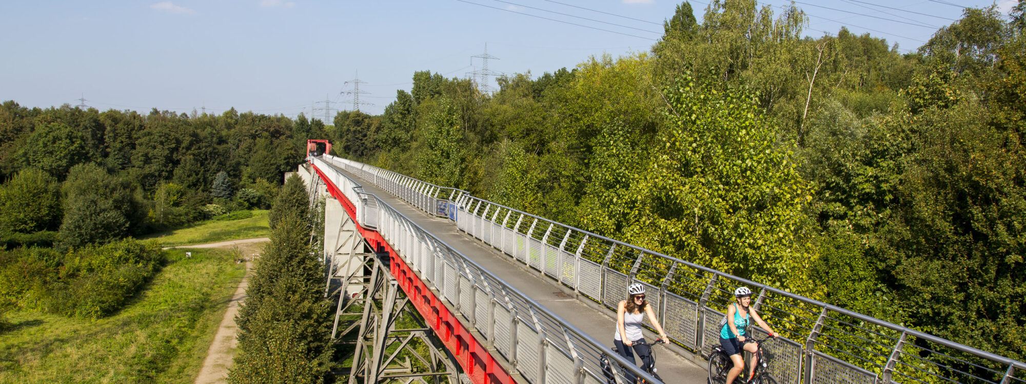Das Foto zeigt zwei Radfahrerinnen auf der Erzbahnbrücke der Erzbahntrasse in Gelsenkirchen auf der RevierRoute Probierstück
