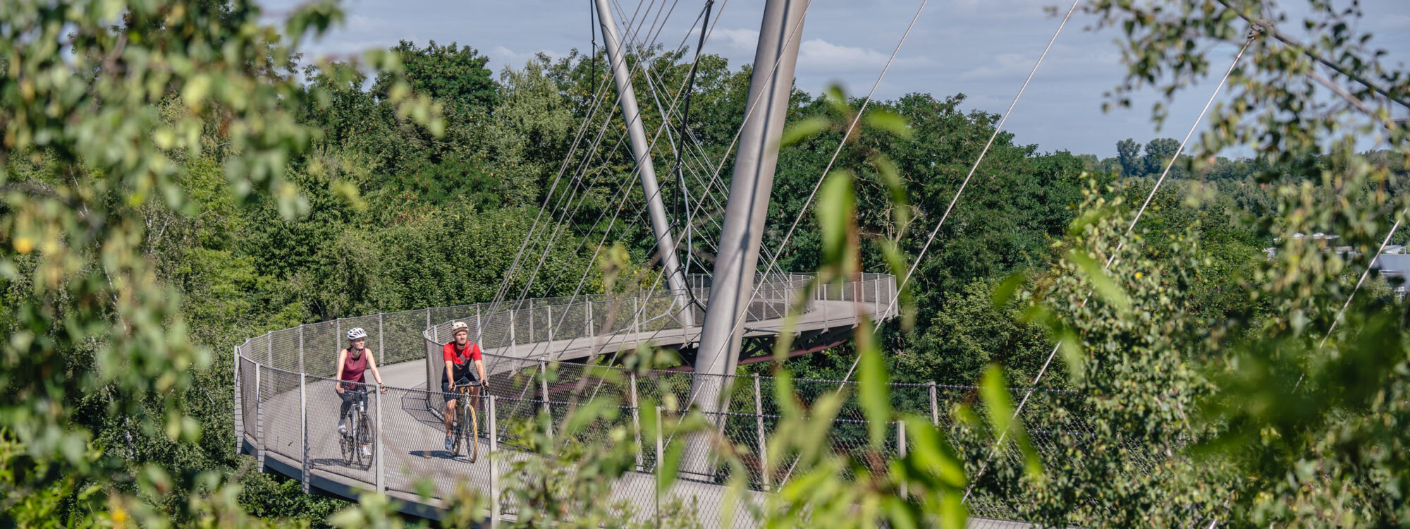 Das Foto zeigt Radfahrende auf der Erzbahnschwinge der Erzbahntrasse in Bochum auf der RevierRoute Bahngeschichte(n)