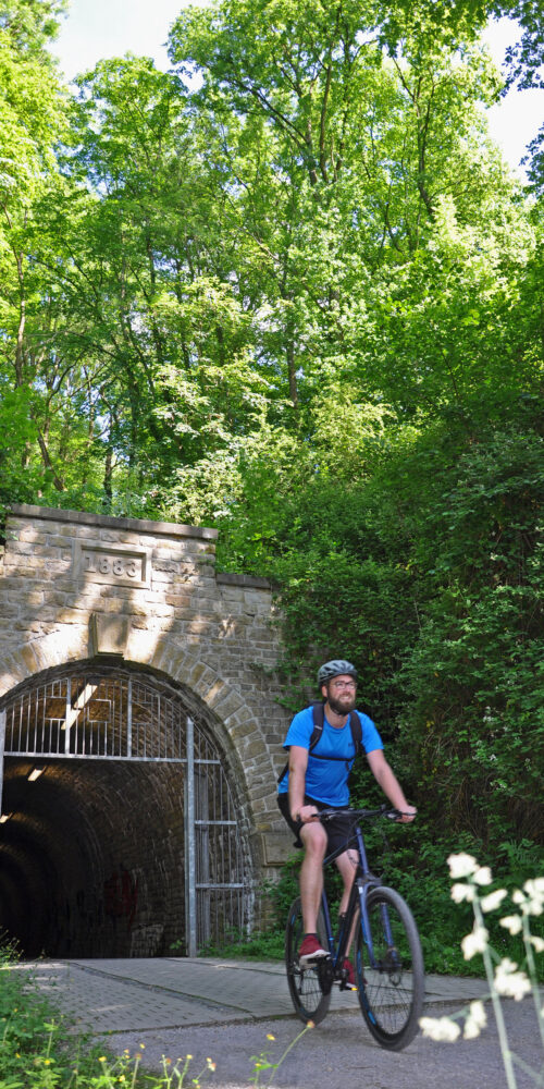 Das Foto zeigt einen Radfahrer auf der Glückauf-Trasse in Hattingen auf der RevierRoute von Ruhr zur Ruhr