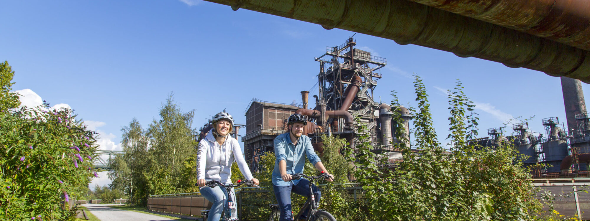 Das Foto zeigt Radfahrende im Landschaftspark Duisburg-Nord auf der RevierRoute Stahlküche