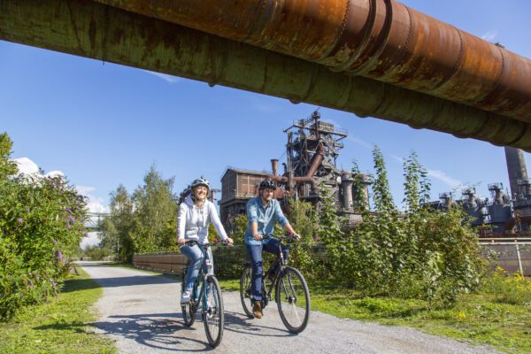 Das Foto zeigt Radfahrende im Landschaftspark Duisburg-Nord auf der RevierRoute Stahlküche