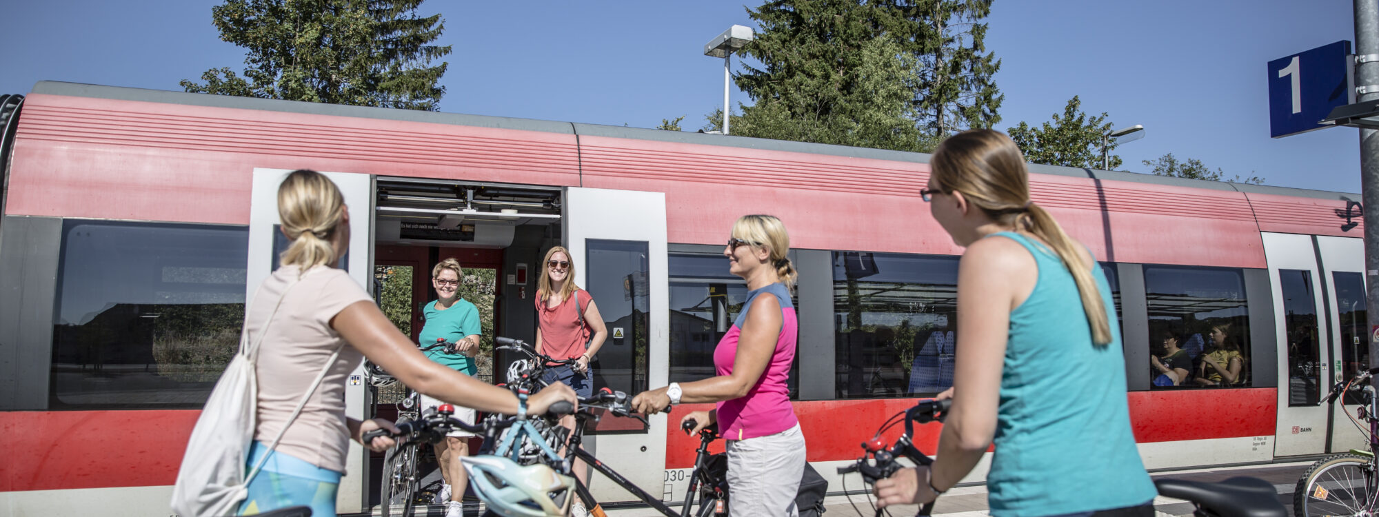 Das Foto zeigt eine Gruppe von Radfahrerinnen bei der Anreise mit der DB am Bahnhof