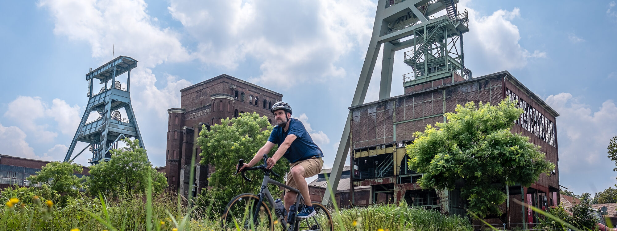 Das Foto zeigt einen Radfahrer auf seinem Gravelbike auf der Route Industriekultur per Rad an der Zeche Ewald in Herten