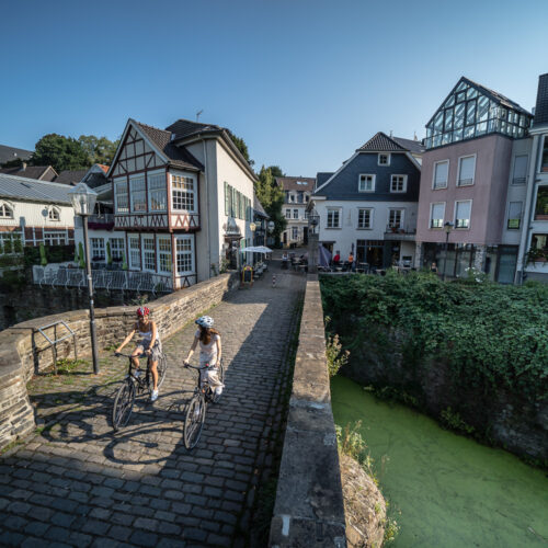 Das Foto zeigt Radfahrende in der Altstadt von Essen Kettwig auf der RevierRoute GartenStadt