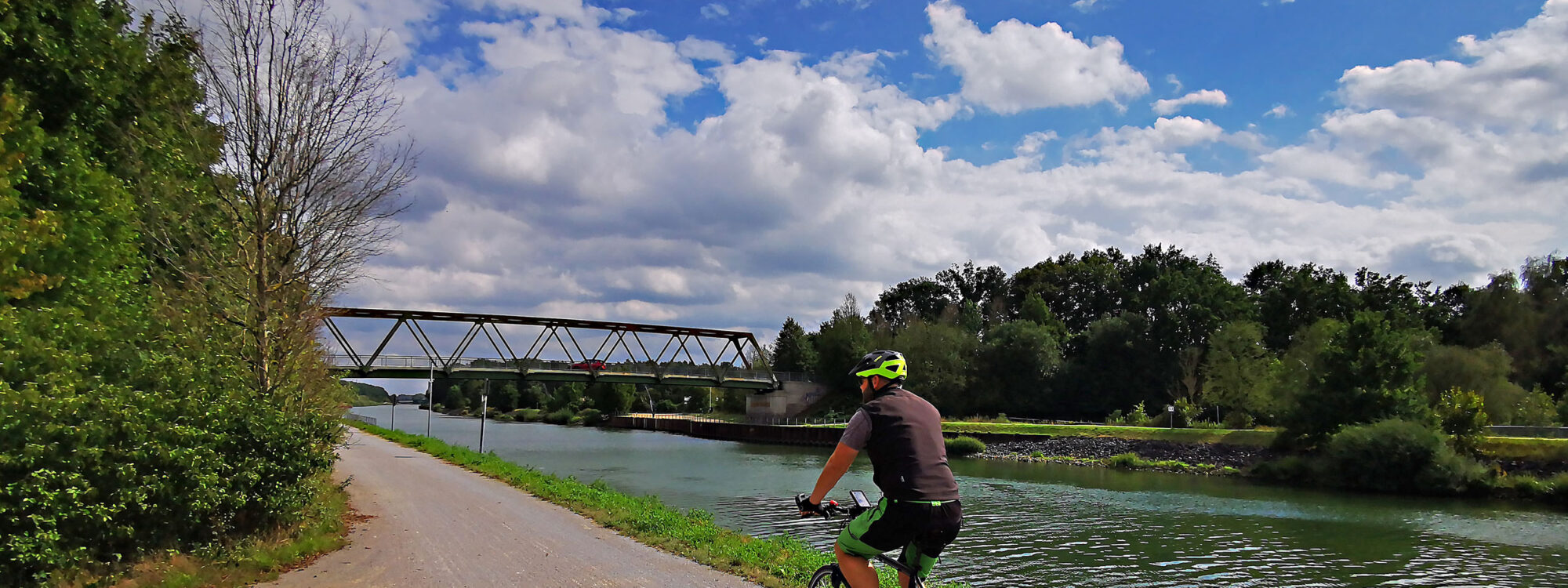 Das Foto zeigt einen Radfahrer auf dem Radweg am Wesel-Datteln-Kanal auf der RevierRoute Kanalpassage