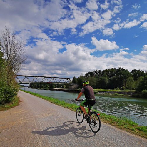 Das Foto zeigt einen Radfahrer auf dem Radweg am Wesel-Datteln-Kanal auf der RevierRoute Kanalpassage