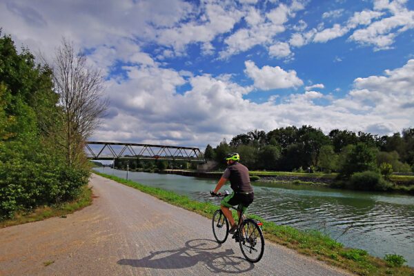 Das Foto zeigt einen Radfahrer auf dem Radweg am Wesel-Datteln-Kanal auf der RevierRoute Kanalpassage