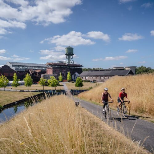 De foto toont fietsers in het Westpark bij de Centennial Hall in Bochum