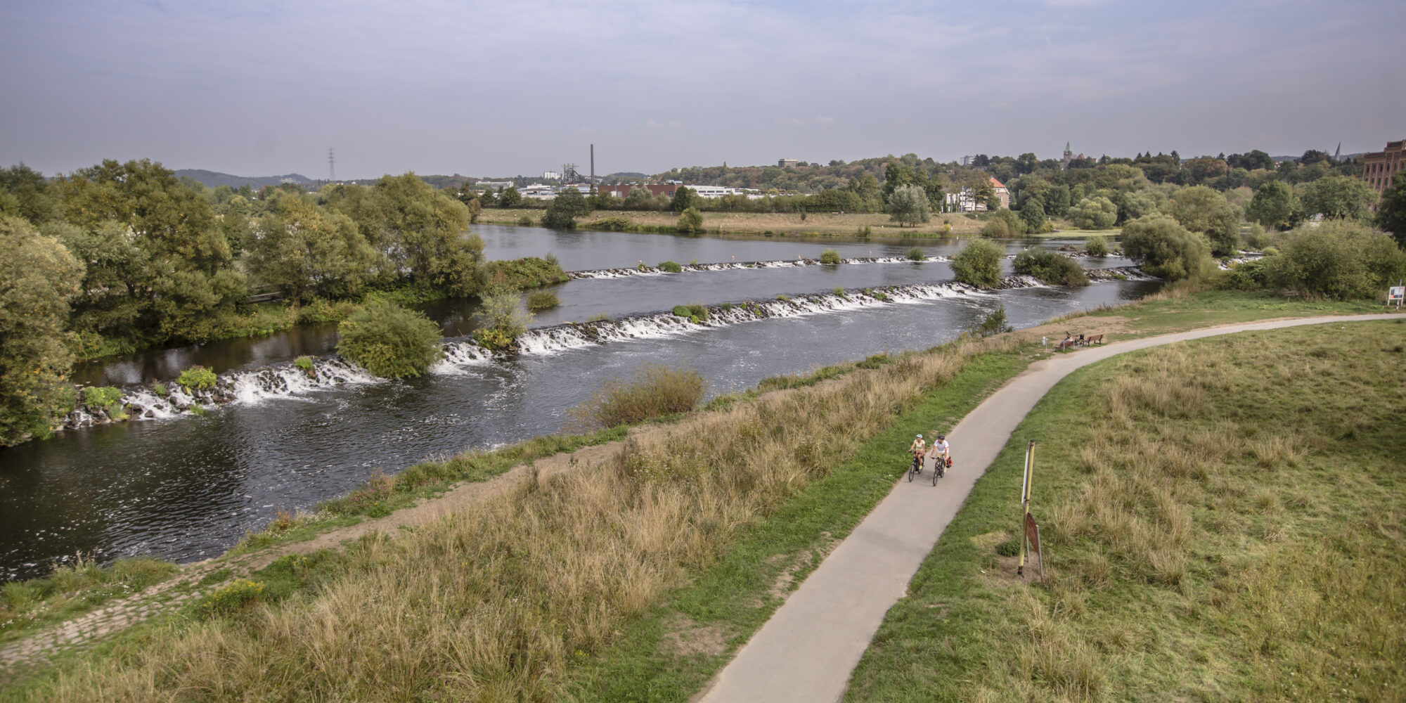 Das Foto zeigt Radfahrende auf dem RuhrtalRadweg an den Ruhrkaskaden in Hattingen