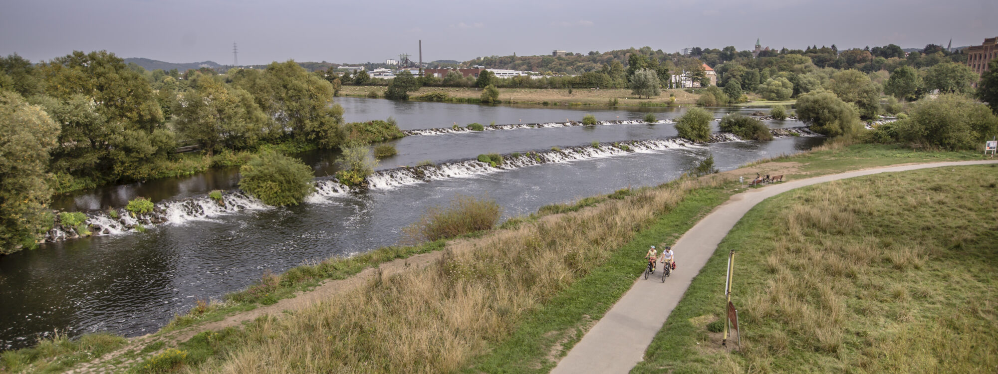 Das Foto zeigt Radfahrende auf dem RuhrtalRadweg an den Ruhrkaskaden in Hattingen